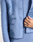 Close up of hand-crochet jacket with blue fern detailing