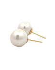 A pair of round pearl stud earrings against a white background.