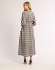 Back of a woman wearing a flannel gray and white checkered dress on a white background