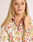 Woman wearing a floral blouse with a neutral background