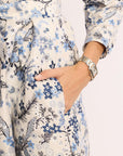 Person wearing a floral dress with blue and black patterns on a white background