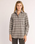 Woman wearing a plaid shirt on a plain background