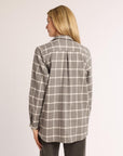 Woman wearing a plaid shirt with a neutral background