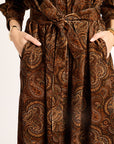 Brown patterned dress with a belt on a white background