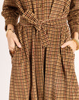 Brown checkered dress with a tie waist on a plain background