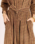 Brown checkered dress with a tie waist on a plain background