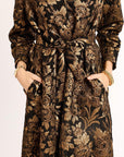 Floral patterned dress with a belt on a plain background