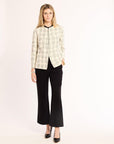 Woman wearing a plaid shirt and black pants on a white background