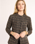 Woman wearing a brown textured jacket on a plain background