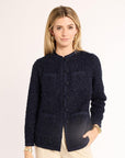 Woman wearing a dark blue textured cardigan on a white background