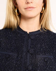 Close-up of a woman wearing a navy button down jacket and gold hoops