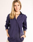 Woman wearing a navy shirt with a plain background