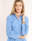 Woman wearing a blue shirt with a plain background