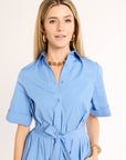 Woman wearing a blue dress with a plain background