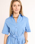 Woman wearing a blue dress with a plain background