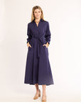 Woman wearing a navy dress with a belt on a white background