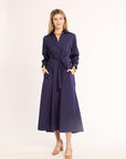Woman wearing a navy dress with a belt on a white background