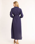 Woman wearing a long navy dress on a white background