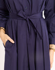 Navy blue dress with a belt on a plain background