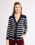 Woman wearing a navy and white striped cardigan against a white background
