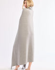 Woman wrapped in a long gray blanket on a white background