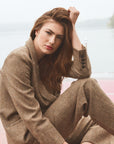 Woman modeling a blazer and pants tweed set on a boat