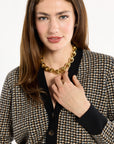 Close-up of the black trim, horn buttons, and check pattern of the Black Tri-Color Check Classic Cashmere Cardigan, photographed against a plain white studio background.