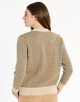 A woman modeling the Camel Tri-Color Check Classic Cashmere Crew with camel trousers, back view, photographed against a plain white studio background.