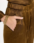Close-up of the elastic waist, pocket, and tonal floral texture of the Golden Umber Diane Pants, photographed against a plain white studio background.