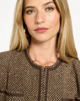 Close-up of the collarless neckline and contrast trim of the Tobacco Tweed Dusti Jacket, photographed against a plain white studio background.