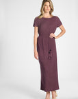 Woman modeling a short sleeve purple pleated dress with a tassel around the waist on a white background