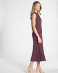 Woman modeling a purple pleated skirt and the matching shell on a white backdrop