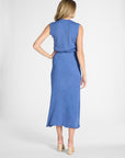 A woman modeling a pleated shell and skirt from the back, standing against a light gray studio background.
