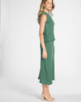 Woman modeling a pleated shell with the matching skirt on a white backdrop