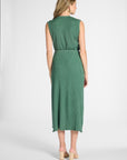 Woman standing wearing a pleated green shell with the matching green skirt on a white backdrop