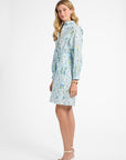 Woman modeling a blue floral mid length dress on a white backdrop
