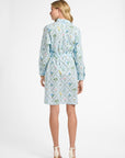 Woman wearing a light blue dress with a geometric floral pattern on a white background