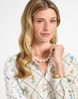 Woman modeling a white floral long sleeve dress on a white backdrop