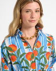 Woman wearing a colorful shirt with orange pattern on a white background