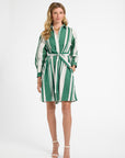 Woman wearing a green and white striped dress on a white background