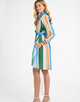 Woman wearing a colorful striped dress on a plain background