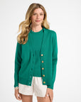Woman wearing a green cardigan with buttons on a white background