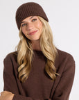 Woman modeling a brown cashmere sweater and hat