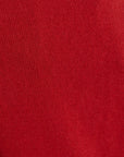 A close-up of a red ribbed knit cashmere texture, showing the detailed weave pattern.
