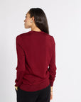 Woman modeling a red tissue cardigan in a studio