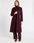 Woman wearing a burgundy cashmere coat in a studio
