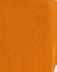 Close-up of a ribbed knit fabric in a warm burnt orange color.