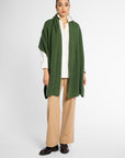 Front view of women wearing a Forest Green cashmere wrap over a white shirt and tan pants in front of a white background