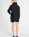 Woman modeling a black cashmere quarter zip in a studio