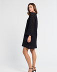 Woman wearing a black dress and black heels on a white background